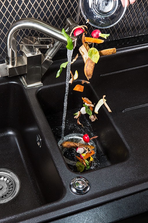 food scraps being put down the garbage disposal