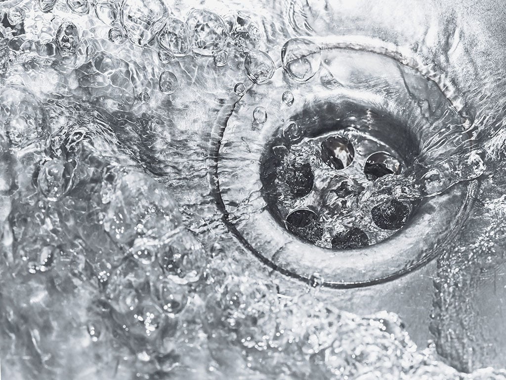 kitchen sink drain with water flowing down it